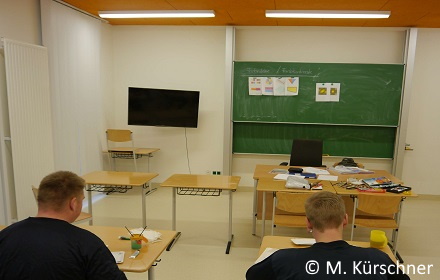 Klassenraum im Schulgebäude der Jugendstrafanstalt Arnstadt mit Lehrertisch, Wandtafel und TV-Gerät.