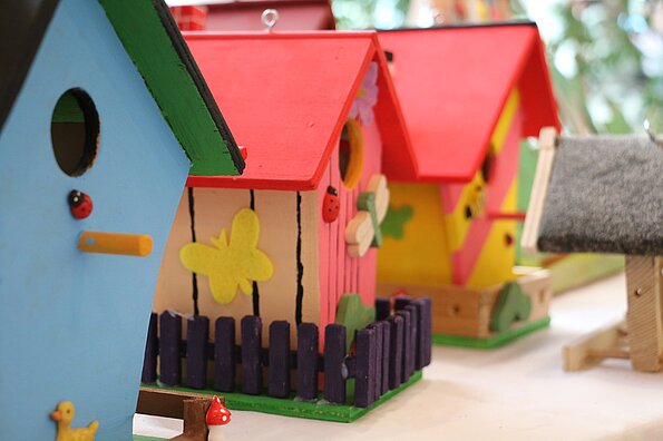 drei Nisthilfen in verschiedenen Farben und Gestaltungsvarianten stehen auf einem Tisch nebeneinander