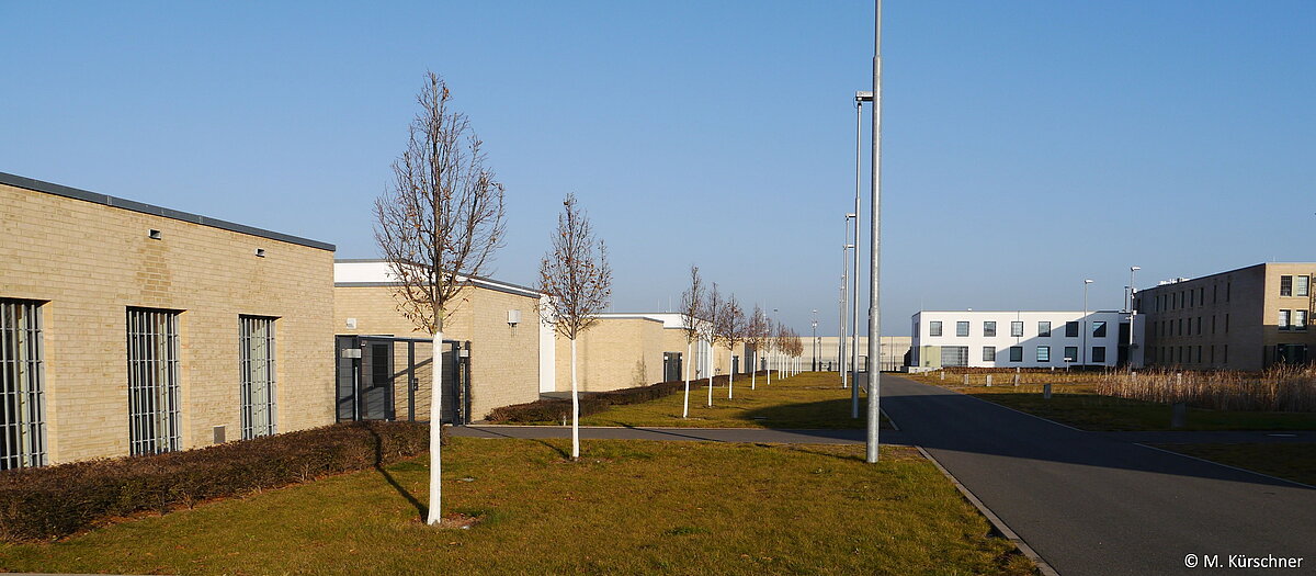 Innenansicht der Jugendstrafanstalt Arnstadt. Auf der linken Seite Schulgebäude und Ausbildungsstätten. Im Hintergrund eines der vier Hafthäuser mit Verwaltungstrakt.