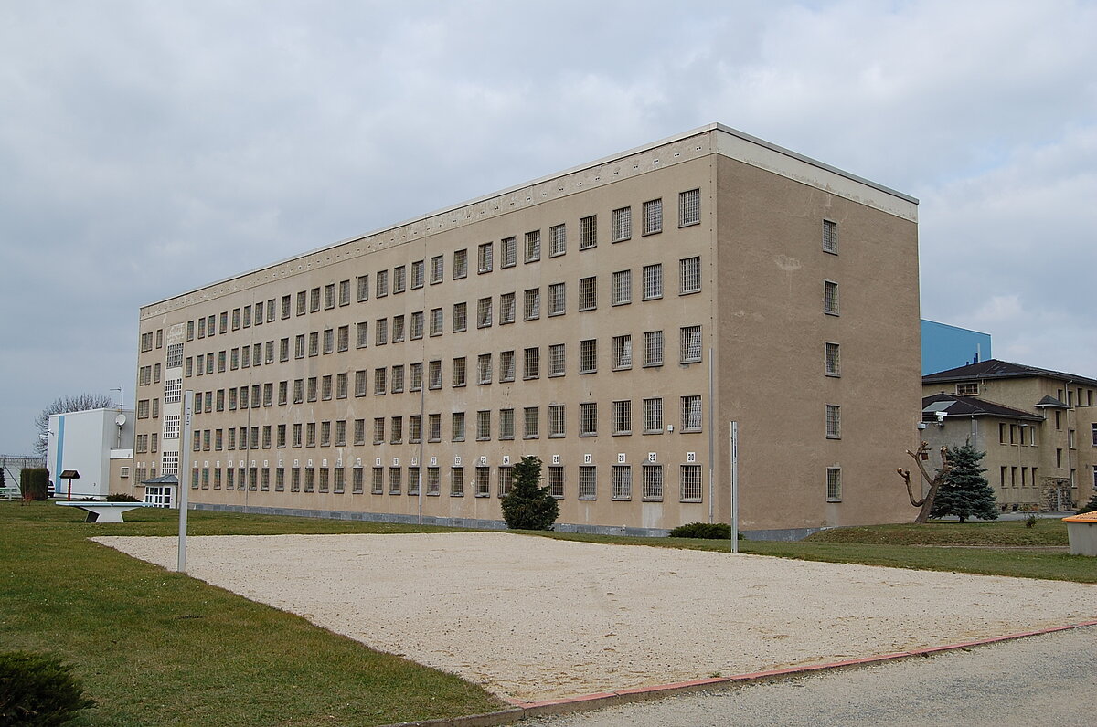 Gebäude der Justizvollzugsanstalt Hohenleuben und im Vordergrund ein Volleyballfeld